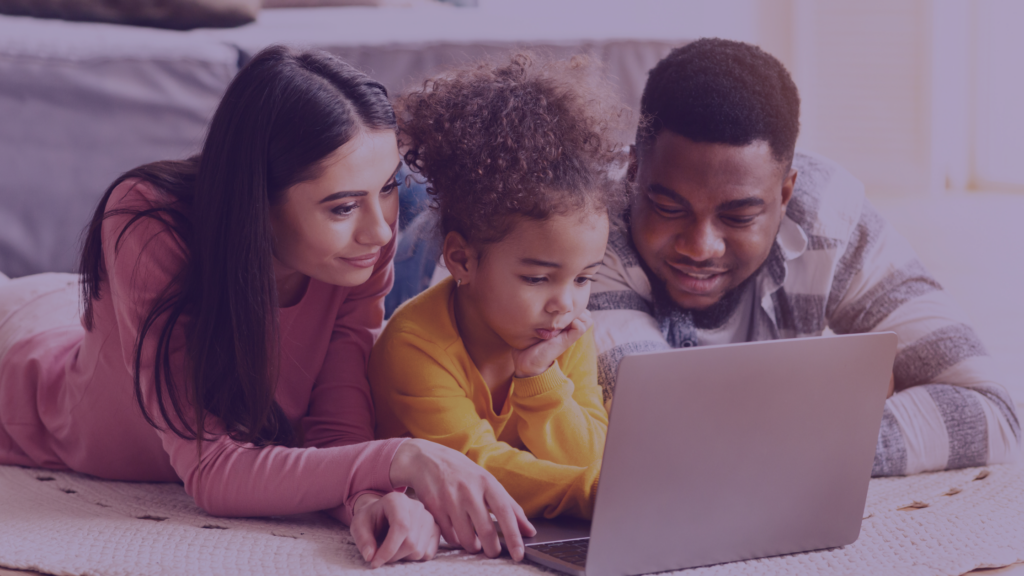 parents showing their daughter something on a computer